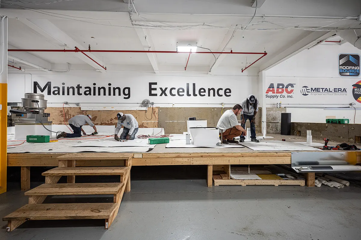 The training hall at headquarters, teammates at work on the mock roof decks