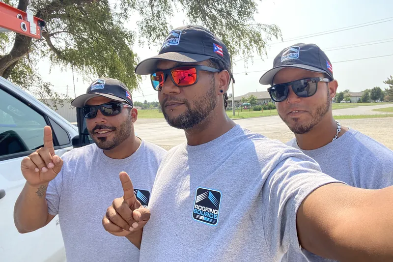 Three Field Advisors in RoofingSource shirts taking a selfie beside a truck