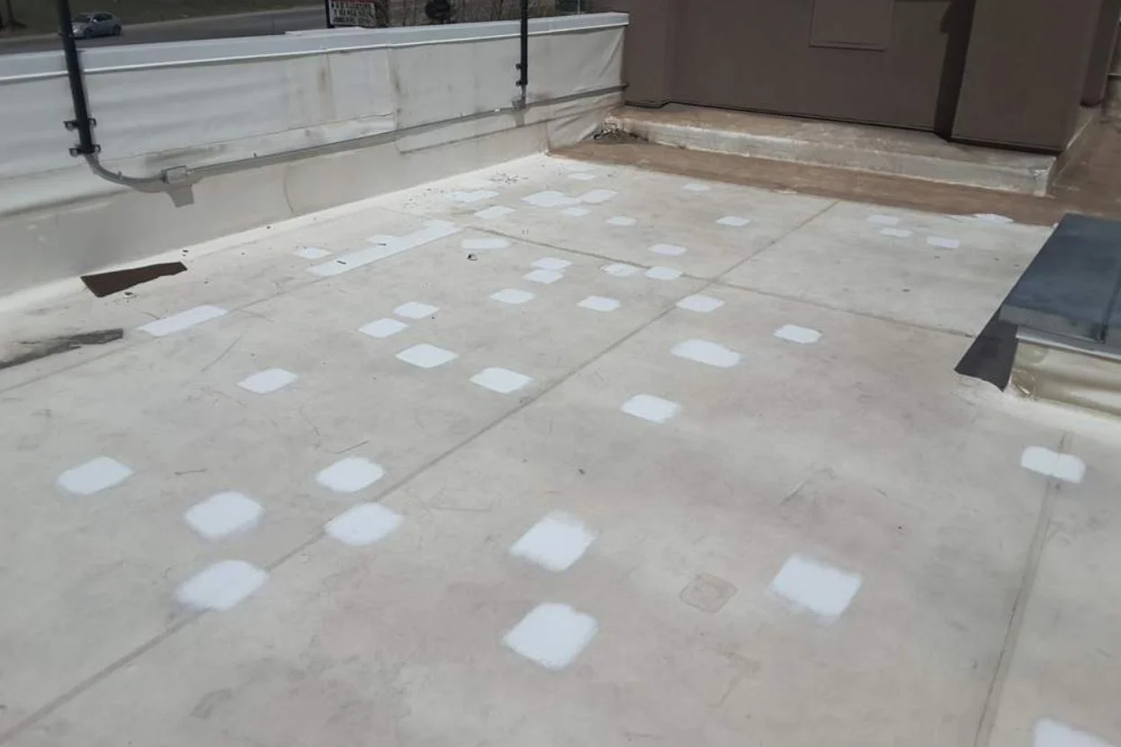 A wide view of a roof deck marked with small white patch areas